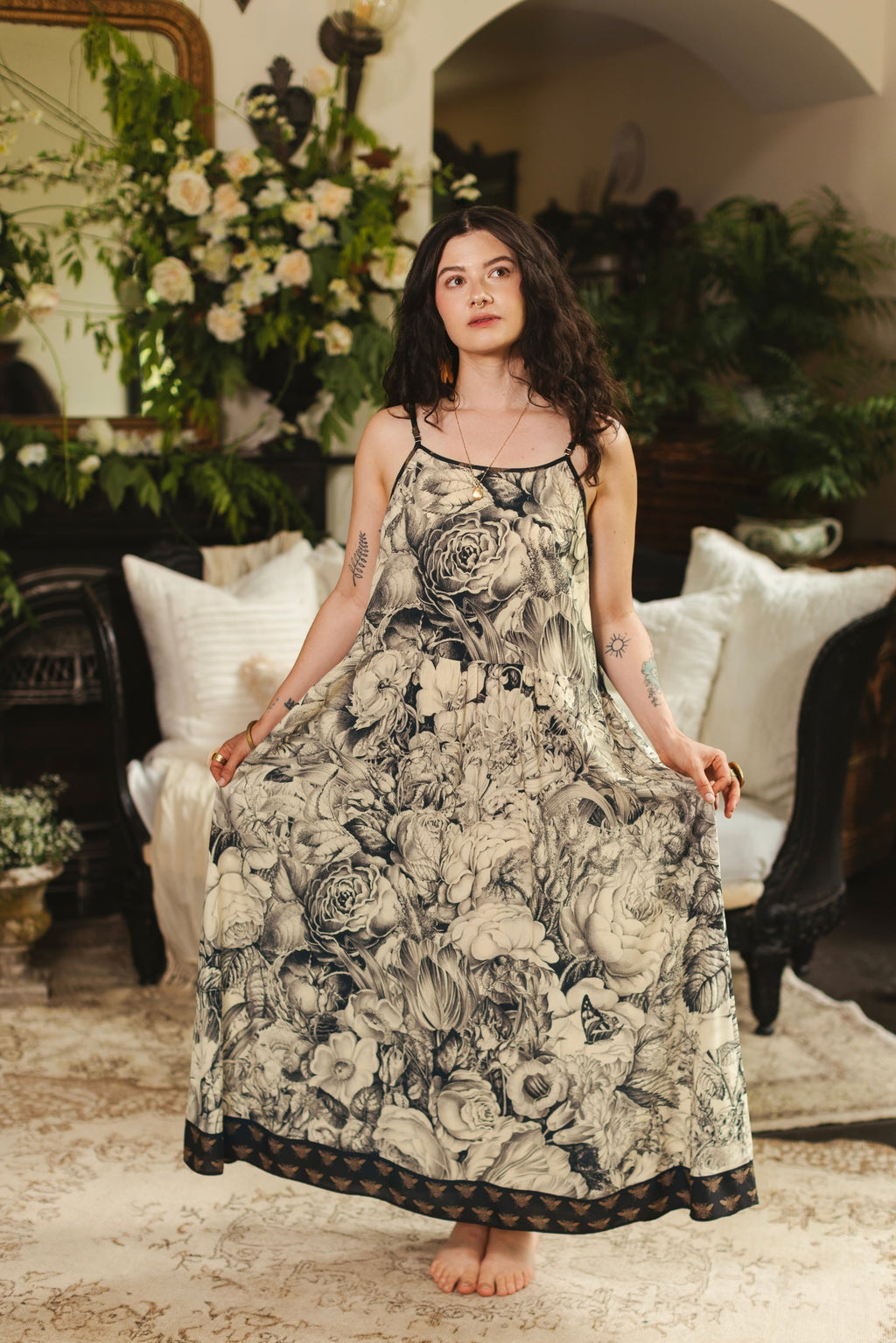 Honey & The Moon Bohéme Slip Dress by Market of Stars. Woman in a black & cream floral print maxi dress with a bee hem.