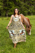 Woman wearing the Born To Run Bohéme Slip Dress by Market of Stars, featuring horse prints, in a field with a horse.