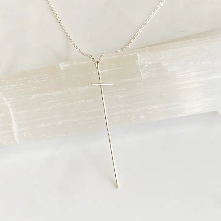 Modern Cross Necklace Sterling Silver by bonnieboardman, featuring an elongated, minimalist silver cross pendant on a delicate chain.