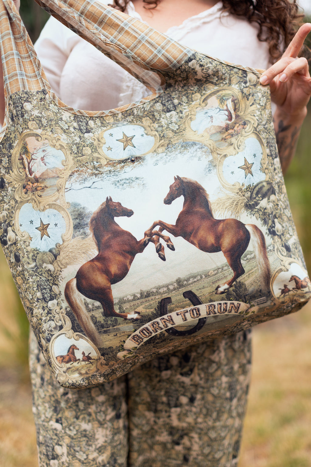 Born To Run Market Tote by Market of Stars, horse-themed print with two rearing horses, ornate details, and plaid handles.