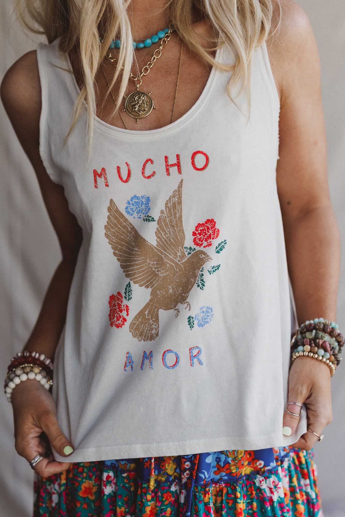 Promesa ET1499G White Smoke Top featuring a 'MUCHO AMOR' graphic with a dove, red and blue flowers. Paired with a colorful skirt.