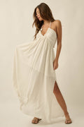 Promesa Roaming Free Cotton Gauze Maxi Dress in Natural, a flowy halter-neck dress with a side slit worn by a model.