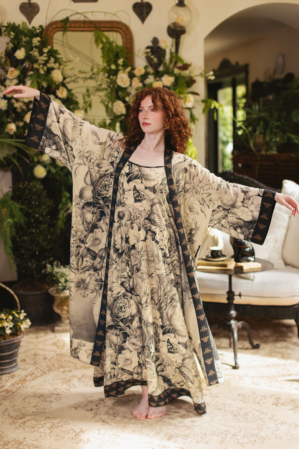 Market of Stars Honey & The Moon Bohéme Slip Dress & kimono with floral print & bee trim on red-haired woman posing indoors.
