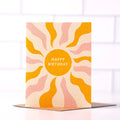Happy Birthday Boho Sun Card by Daydream Prints. Textured card with orange sun, pink/orange wavy rays, standing on a brown envelope.
