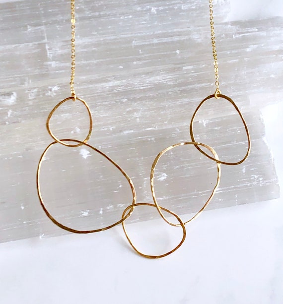 Bonnieboardman River Rock Necklace 14kt Gold Fill, featuring hammered organic shaped rings on a white background.
