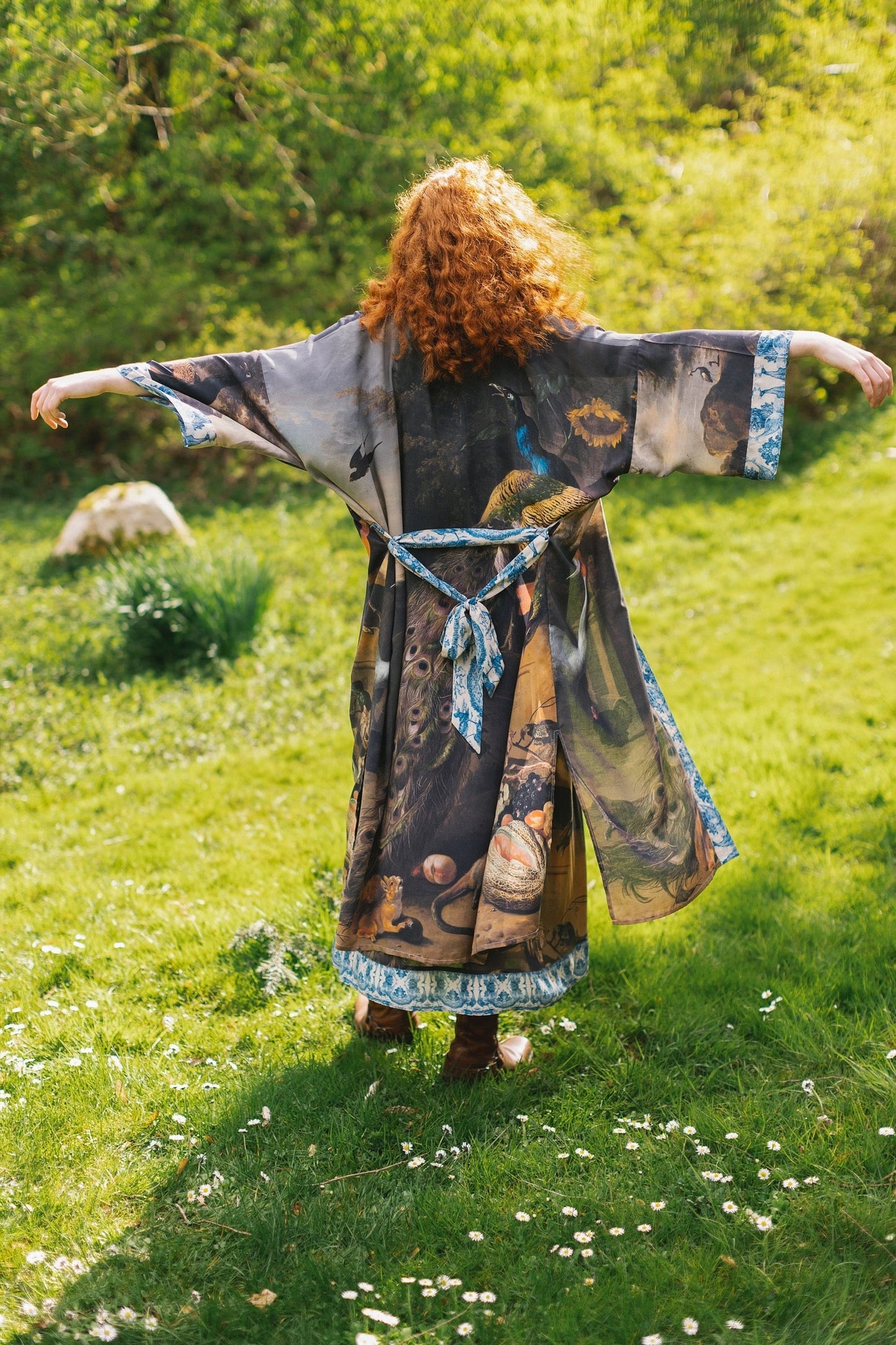 Wild Beauty Opera Duster by Market of Stars with vibrant nature and animal print, worn by a red-haired person in a grassy field.