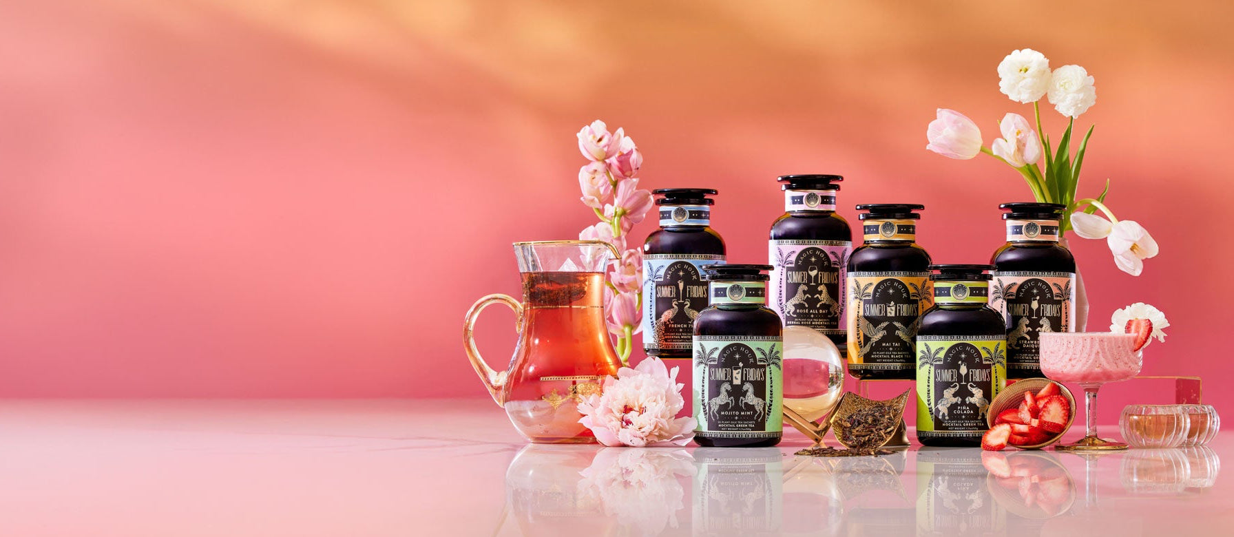 Magic Hour Aquamarine Dream Herbal Adrenal Tonic & other Summer Fridays bottled teas, with flowers, a tea pitcher, and strawberries.