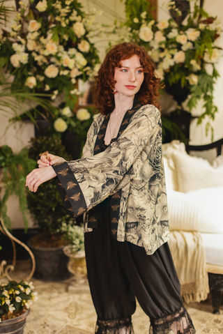 Woman modeling Market of Stars Honey & The Moon Pixie Duster, a unique patterned kimono with bee-print cuffs and black pants.