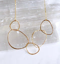 bonnieboardman gold River Rock Necklace, featuring hammered, organic-shaped links, on a subtly textured white backdrop.