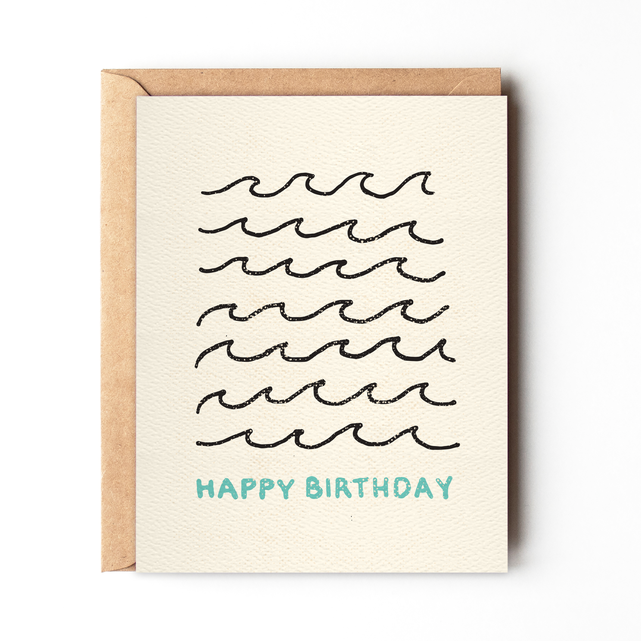 Happy Birthday Wave Card by Daydream Prints. Light cream card with black wave pattern and blue 'Happy Birthday' text, kraft envelope.