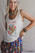 Promesa ET1499G White Smoke Top with 'Mucho Amor' bird graphic, styled on a smiling woman with a floral skirt & accessories.