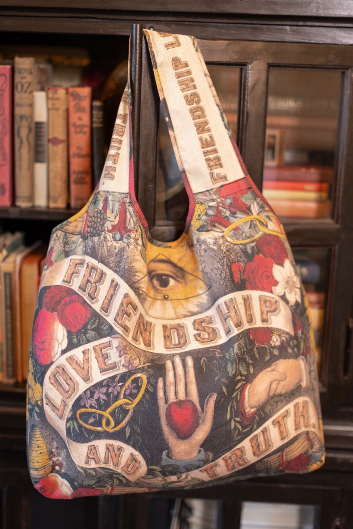 Friendship Love & Truth Market Tote Bag from Market of Stars, with intricate vintage art of an eye, hands, hearts, and roses.