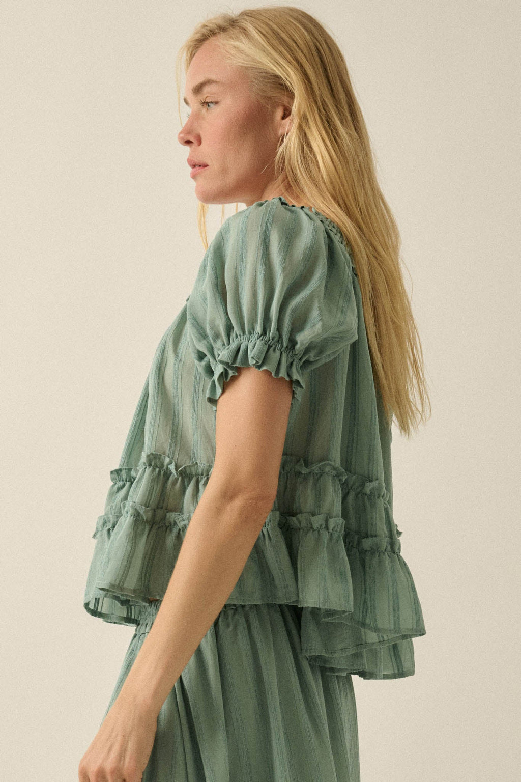 Promesa Precious Days Ruffle Babydoll Top in Pine Green. Woman models the tiered ruffle top with puff sleeves.